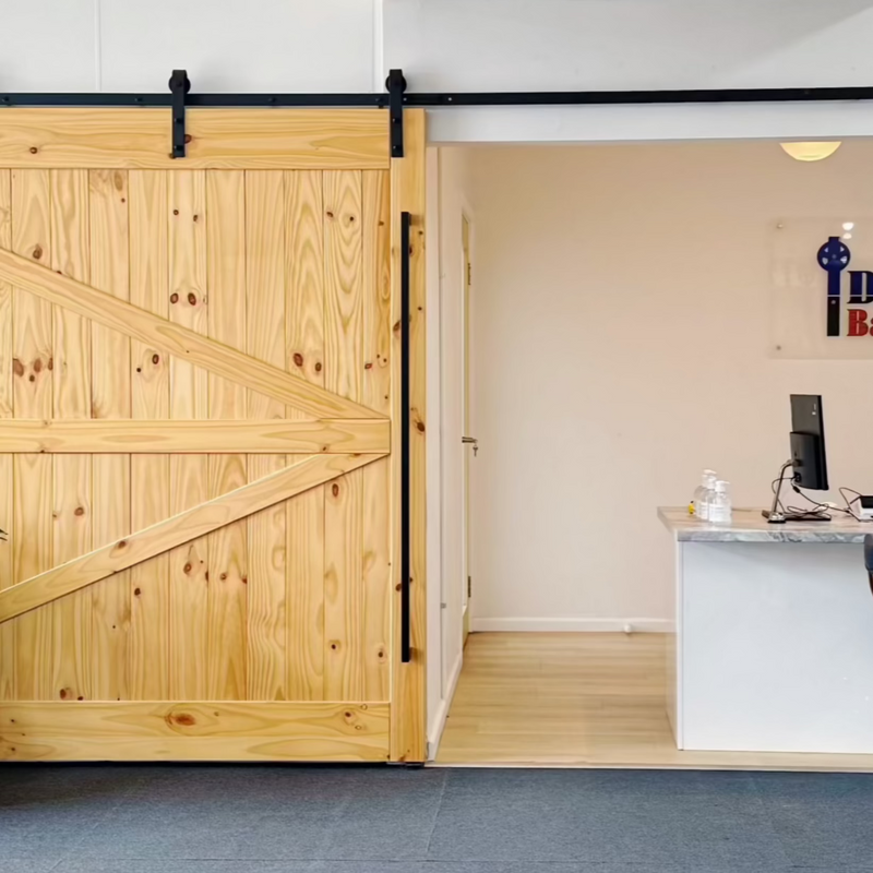 Wooden sliding door in a modern interior setting with a desk and computer.