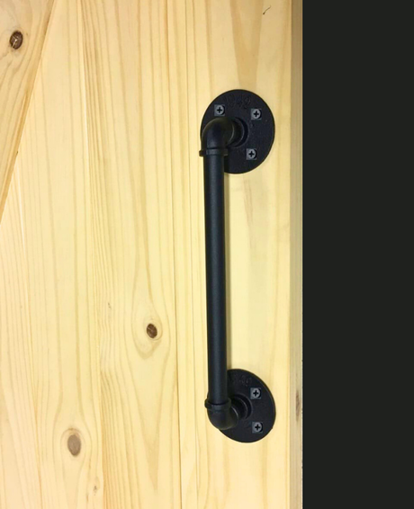 Black industrial-style door handle on a wooden door